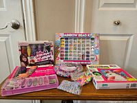 Full view of craft and bead kits arranged on a table including bead kits, jelly art gel, and safety pin bracelet kit