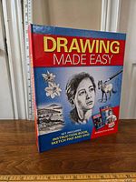 Front view of the Drawing Made Easy set including book, sketch pad, and DVD.