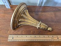 Top and side view of the gold Florentine demi lune wall shelf showing carved fluted detailing and curved shelf shape.