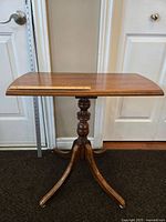 Full view of vintage wooden side table in warm wood tone with measuring ruler placed on top showing width.