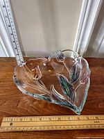 Heart shaped candy dish with blue and pink raised tulip decorations placed next to a ruler showing size for scale.