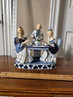Front view of the Victorian porcelain tea party statue with scale rulers showing size
