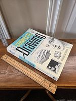 Front cover of 'The Complete Book Of Drawing' by Barrington Barber showing detailed pencil illustrations and title text with rulers for size reference.