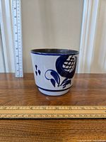 Front view of the West Germany pottery planter with blue floral design, showing shape and size with ruler nearby.