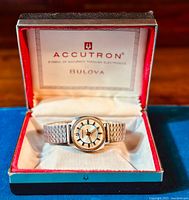 Watch and expandable bracelet displayed inside original Accutron Bulova box with red and white interior lining.