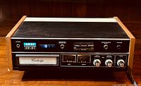 Front angled view of vintage Akai CR-81 8-track stereo tape deck showing wood side panels, front panel controls, and cartridge slot.