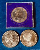 Top-down photo of the three coins with the Silver Wedding Crown in case and two £5 coins. The Diana coin shows profile bust and memorial inscription.