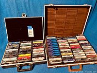 Two open briefcases filled with cassette tapes from the 1980s showing overall lot quantity and storage method