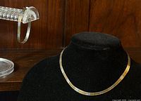 Photo showing the sterling silver fancy link necklace on a black bust and bracelet on a clear acrylic stand, highlighting the polished silver finish and link pattern.