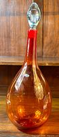 Full front view of the tangerine decanter with stopper inserted
