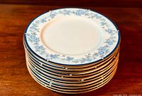 Stack of 10 dinner plates showing edge details and gold trim.