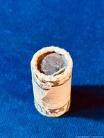 View of the closed roll showing the edge of the coins inside the paper wrapping.