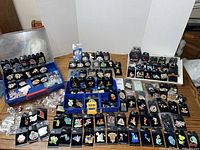 Pins displayed in three plastic storage cases and laid out on table