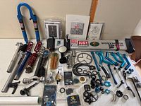 Overview of all components laid out on a table including forks, springs, repair stand, manuals, stems, and small parts.