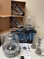 Two Harman Kardon Soundsticks Wireless sets with subwoofers and satellites alongside one original box
