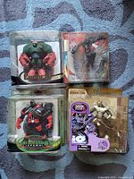 Front view photo of four unopened McFarlane Spawn action figures: Creech, Spawn, Commando Spawn, and Shadow Hawk in original packaging laid on carpet.
