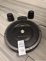 iRobot Roomba vacuum robot with charging base and two wall sensors all placed on floor to show the lot contents