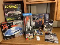 Full lot showing two Lost In Space kits, Complex 39 shuttle model, Discovery Channel lunar set, magazines and books