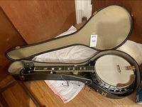 Open black hard shell case with 5-string banjo inside