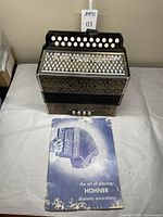 Accordion and instructional booklet displayed on table, front view