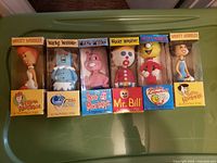 Front view of six Wacky Wobbler bobbleheads boxed: Wilma Flintstone, Rosie the Robot, Sea-Monkeys, Mr. Bill, Reddy Kilowatt, Betty Rubble