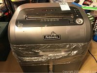 Front view of Fellowes paper shredder with lot number label and shredding slot visible.