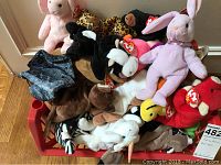 Photo showing over 30 assorted Beanie Babies plush toys in a red bin, various animals and colors visible