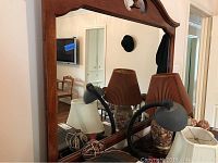 Close-up of the large mirror attached to the dresser, showing wood frame and decorative top.