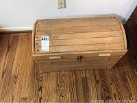 Top view of wooden trunk showing slatted wood curved lid and latch on front side