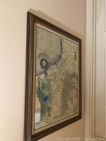 Side angled photo of framed map highlighting wood frame and wall mounting.