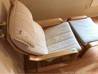 Wood frame chair with white cushions, showing front and side profile, demonstrating good condition and canvas seat and back support.