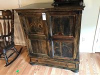 Front view of the solid wood television cabinet showing two paneled doors and bottom drawer.