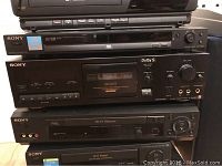 Stacked Sony DVD player, cassette deck RX606ES, Hi-Fi stereo units, and other media electronics.