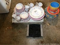 Full set of Johnson Brothers Summer Chintz China including plates, cups, saucers and tray, alongside colorful Mexican style dishes.