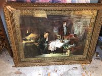 Close-up photo showing large ornate gold framed figurative print with two men and a baby in an interior setting
