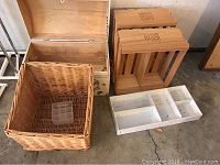 Photo displaying wooden crates, wicker basket, small wooden trunk, and plastic shoe racks stacked together.