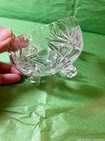 Side angled view showing bowl's intricate starburst cut design and three rounded feet.