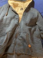 Full front view of the blue/turquoise David Bitton hoodie with sherpa lining visible at the hood and pocket edges.