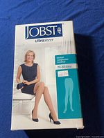 Box of JOBST UltraSheer medical compression stockings showing packaging with a woman seated wearing similar stockings.