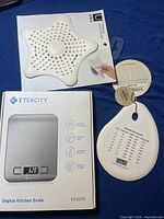 Etekcity digital kitchen scale box front and Umbra hair catcher and KitchenPlus dough scraper visible