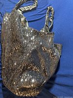 Full view of the black sequin-covered shoulder bag with padded twisted faux leather handles