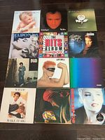 Top view of all 12 LP records arranged in three rows, showing album covers including Van Halen, Phil Collins, Fleetwood Mac, Madonna, and others.