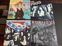 Four vintage LP records in their original sleeves, arranged in a grid pattern, showing cover art and band names clearly.