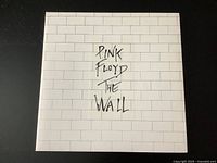 Front cover of the vinyl record album showing the white brick wall design with handwritten text 'Pink Floyd The Wall'.