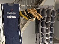 Photo showing wooden hangers, garment bag, and hanging organizers on rack