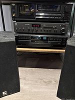 Stack showing Aiwa cassette deck on top, NAD receiver middle, Sony CD changer bottom, with one Celestion speaker at left