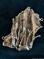 Front view of the ornate sterling silver mezuzah showing the intricate openwork design and Hebrew lettering on the prayer scroll inside the glass tube.