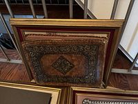 Large vintage gilded frame and vintage leather photo album with detailed embossing and wear