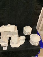 White unpainted ceramic Christmas village building set including a large building and two smaller structures.