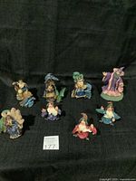 Overview of nine collectible wizard figurines arranged on a black fabric surface.